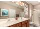 Bathroom featuring a double sink vanity, large mirror, and a walk-in shower at 227 W Lantern Way, San Tan Valley, AZ 85143