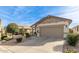 Lovely single-story home with desert landscaping, a two-car garage and spacious driveway at 227 W Lantern Way, San Tan Valley, AZ 85143