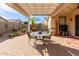 Inviting outdoor patio with a dining table set under a charming pergola, perfect for outdoor entertaining at 227 W Lantern Way, San Tan Valley, AZ 85143