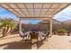 Inviting outdoor patio with a dining table set under a charming pergola, perfect for outdoor entertaining at 227 W Lantern Way, San Tan Valley, AZ 85143