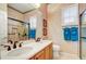 Bathroom featuring a dual sink vanity, glass enclosed shower, and patterned wallpaper at 22742 N 90Th St, Scottsdale, AZ 85255