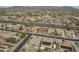 High-angle shot of the suburban neighborhood, near desert landscape, featuring well-maintained streets, homes, and a highway at 22949 W Yavapai St, Buckeye, AZ 85326