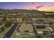 Aerial view of a neighborhood featuring uniform homes against a colorful dusk sky at 22949 W Yavapai St, Buckeye, AZ 85326