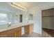 This bathroom features a double sink vanity with wooden cabinets, a large mirror, and a shower at 22949 W Yavapai St, Buckeye, AZ 85326