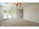 A bedroom features carpet, a ceiling fan, and glass patio doors to the covered patio at 22949 W Yavapai St, Buckeye, AZ 85326