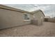 Exterior side view of the home with gravel landscaping and a privacy fence at 22949 W Yavapai St, Buckeye, AZ 85326