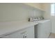 The laundry room features a countertop, cabinetry, a washer, and a dryer at 22949 W Yavapai St, Buckeye, AZ 85326