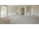 Open-concept living space with plush gray carpet, and bright, neutral walls at 22949 W Yavapai St, Buckeye, AZ 85326