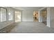 Bright open-concept living room features new gray carpet, with a view to the kitchen at 22949 W Yavapai St, Buckeye, AZ 85326