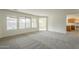 Bright living room with plush gray carpet, large windows, and view to the pool area at 22949 W Yavapai St, Buckeye, AZ 85326