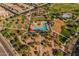 Aerial view of a resort-style community pool, playground and shaded seating with lush landscaping throughout at 23004 E Desert Spoon Dr, Queen Creek, AZ 85142