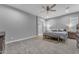 Bright bedroom featuring neutral paint, carpeted floors, ceiling fan and ensuite bathroom at 23004 E Desert Spoon Dr, Queen Creek, AZ 85142