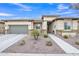 Well-maintained single-story home with a two-car garage and attractive desert landscaping in the front yard at 23004 E Desert Spoon Dr, Queen Creek, AZ 85142