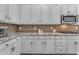 Close up of the kitchen featuring stainless steel appliances, white cabinets, and decorative hardware at 23004 E Desert Spoon Dr, Queen Creek, AZ 85142