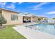 An inviting backyard pool features an umbrella, seating area, artificial grass, and a serene atmosphere at 23004 E Desert Spoon Dr, Queen Creek, AZ 85142