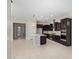 Spacious open-concept kitchen with an island, dark cabinets, and stainless steel appliances at 23072 N 98Th N Dr, Peoria, AZ 85383