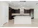 Kitchen featuring a center island, stainless steel range hood, and dark wood cabinets at 23072 N 98Th N Dr, Peoria, AZ 85383