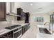 Modern kitchen featuring dark cabinets, stainless steel appliances, and quartz countertops at 23072 N 98Th N Dr, Peoria, AZ 85383