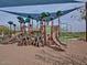 Community playground featuring slides and climbing structures on a sand base, shaded by a large awning at 23072 N 98Th N Dr, Peoria, AZ 85383