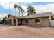 Single-story brick home featuring a low-maintenance gravel yard, arched entryway, and large windows under a bright blue sky at 2671 W Bentrup St, Chandler, AZ 85224