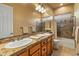 Double sink vanity and mirror in a full bathroom with a tub and tiled shower at 27561 N 84Th Dr, Peoria, AZ 85383