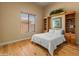 Cozy bedroom with a built-in headboard with shelving, hardwood floors, and natural light at 27561 N 84Th Dr, Peoria, AZ 85383