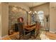 Elegant dining area featuring stone accent wall, chandelier, and decorative rug at 27561 N 84Th Dr, Peoria, AZ 85383