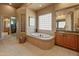 Bright bathroom featuring a soaking tub, tiled floors, and glass block window at 27561 N 84Th Dr, Peoria, AZ 85383