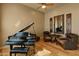 Cozy piano room with black grand piano, armchairs, and decorative mirror at 27561 N 84Th Dr, Peoria, AZ 85383