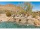 Resort-style pool with waterfall feature and sun loungers against a scenic mountain backdrop at 27561 N 84Th Dr, Peoria, AZ 85383