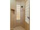 A shower stall featuring decorative glass block windows, neutral tile, and detailed trim at 27561 N 84Th Dr, Peoria, AZ 85383