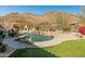 Beautiful backyard pool with mountain views, fireplace, and lounge seating at 27561 N 84Th Dr, Peoria, AZ 85383