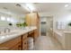 Bright bathroom featuring tile floors, dual vanity, and a large mirror at 2856 N 152Nd Ln, Goodyear, AZ 85395