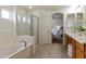 Bright bathroom featuring tile floors, garden tub, and a separate glass shower enclosure at 2856 N 152Nd Ln, Goodyear, AZ 85395