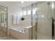 Bright bathroom featuring tile floors, garden tub, and a separate glass shower enclosure at 2856 N 152Nd Ln, Goodyear, AZ 85395