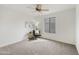 Bright bedroom featuring carpet floors, a ceiling fan, and a large window for plenty of natural light at 2856 N 152Nd Ln, Goodyear, AZ 85395