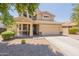 Two-story tan home with a large attached garage and a well-manicured, low-maintenance desert landscape at 2856 N 152Nd Ln, Goodyear, AZ 85395