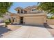 Two-story tan home with a large attached garage and a well-manicured, low-maintenance desert landscape at 2856 N 152Nd Ln, Goodyear, AZ 85395