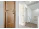 Hallway with wood cabinets, carpet flooring, white walls, and views of an open door at 2856 N 152Nd Ln, Goodyear, AZ 85395