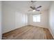 A bright, empty bedroom with a ceiling fan, wood-look floors, and a closet at 2923 E Wahalla Ln, Phoenix, AZ 85050