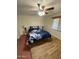 Bright bedroom featuring light wood flooring, window with blinds, and blue floral bedding at 2923 E Wahalla Ln, Phoenix, AZ 85050