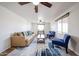 Bright living room with neutral sofa, blue accent chairs, ceiling fans and a patterned rug at 2923 E Wahalla Ln, Phoenix, AZ 85050