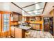 Kitchen featuring terracotta tile, orange walls, wooden cabinetry, and island with seating at 2929 N 55Th Pl, Phoenix, AZ 85018