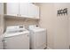 Laundry room with side-by-side, full-sized washer and dryer beneath white cabinets at 3131 E Legacy Dr # 2101, Phoenix, AZ 85042