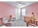 Bedroom with pink walls, ceiling fan, and baby furniture at 31400 N 130Th Ave, Peoria, AZ 85383