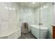 Bright bathroom featuring a marble walk-in shower, soaking tub, and gray tile at 3238 E Ashurst Dr, Phoenix, AZ 85048