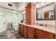 Bathroom featuring a marble walk-in shower, double sink vanity, and granite countertops at 3238 E Ashurst Dr, Phoenix, AZ 85048