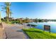 Private waterfront property boasts a tranquil lake view with a pier, complemented by lush landscaping and palm trees at 3238 E Ashurst Dr, Phoenix, AZ 85048