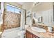 Bathroom features a tub/shower combo with tile surround, and a vanity with a sink and cabinet at 34014 N 43Rd St, Cave Creek, AZ 85331