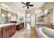 This is a bathroom featuring dual sinks, a soaking tub, and a tiled shower with glass door at 34014 N 43Rd St, Cave Creek, AZ 85331